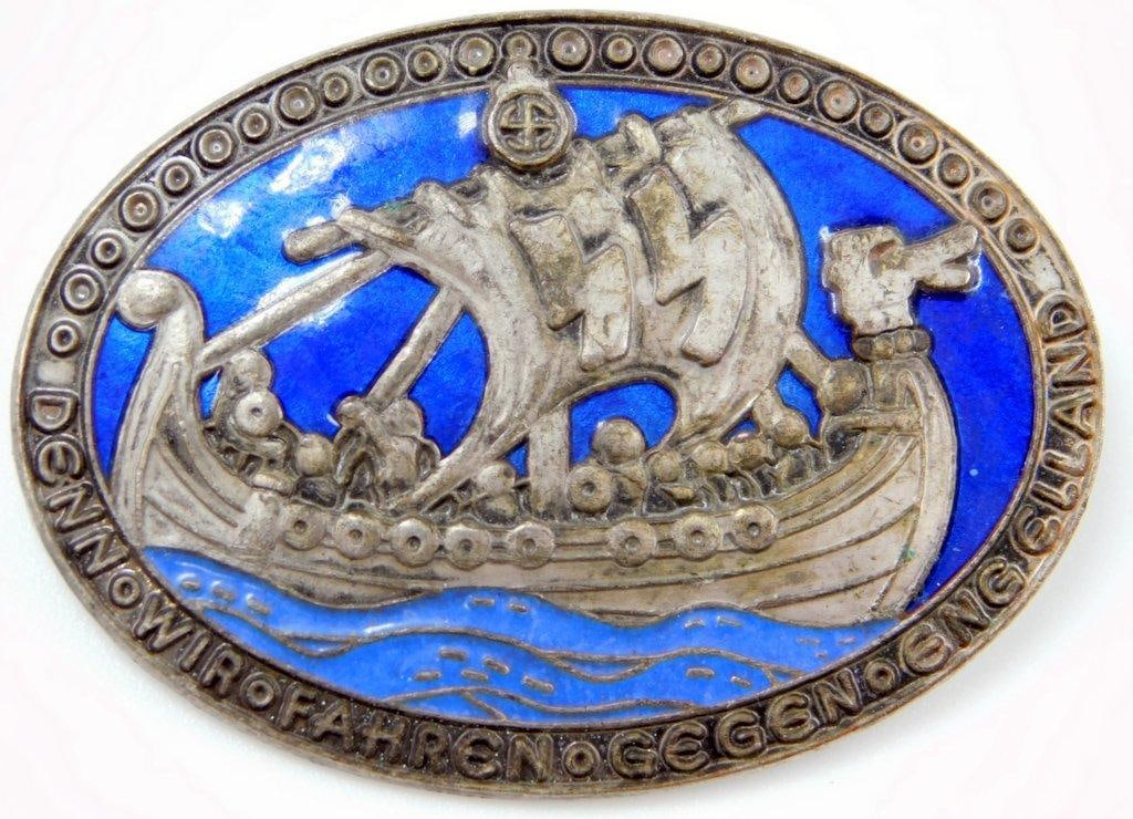 Waffen SS Victory In England Badge: One-piece die-struck vaulted nickel construction with enamel. Front shows a Viking ship with a pair of Waffen SS runics in the sail. Reads Denn Fahren Gegen Eng Elland. Reverse is maker marked ge