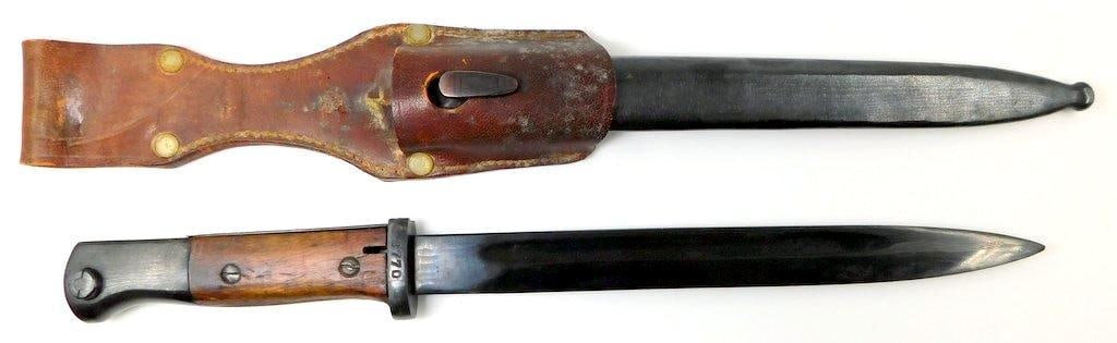 German WWII Mauser K-98 Combat Rifle Bayonet and Scabbard: Excellent-plus condition on this very fine German combat bayonet. Cross guard is marked 8770 P R 8. Pair of brown wood handles. Includes the brown leather belt frog. Measures 17 9/16 inches long 