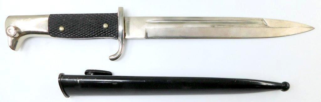 German WWII Dress Bayonet and Scabbard Short Model: Steel blade measures 1 inches wide by 7 7/8 inches long. Black-painted steel scabbard measures 1 1/8 inches wide by 8 7/8 inches long. Pair of black checkered bakelite handles. Measures 13 5