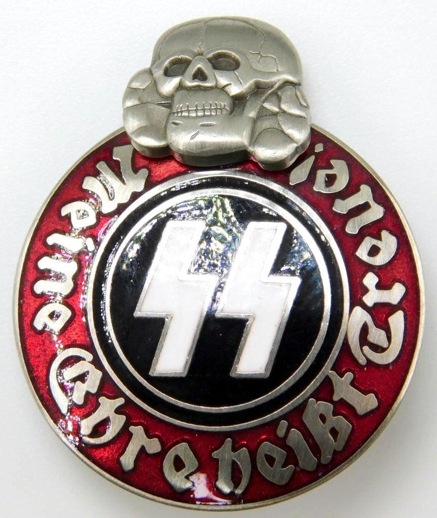 German WWII Waffen SS Schutz Staffel Membership Badge: Two-piece nickel construction with black, red and white enamel. Front reads Meine Ehre heist Treue! (My Honor is Loyalty!). Pair of SS runics with a skull at the top. Reverse is maker-marked RZM M13/4