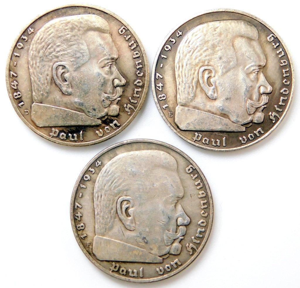 German WWII Chancellor Paul von Hindenburg 5 Mark Silver Coins, Three (3): Excellent condition. Die-struck construction. Front reads Paul von Hindenburg 1847 1934. Shows a bust profile image of him in the center. Reverse shows a German eagle clutching a swastika in its talon