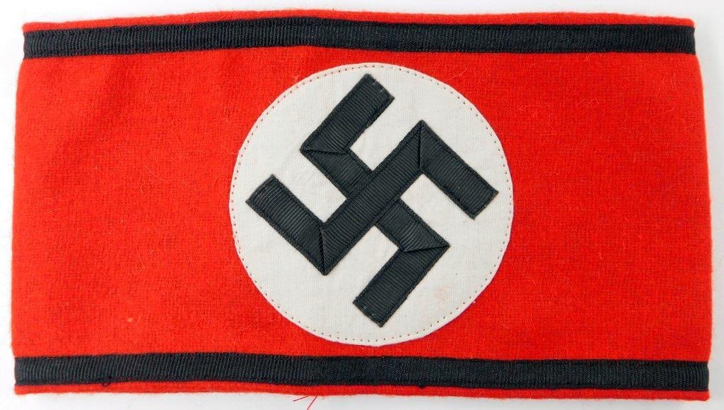 German WWII Waffen SS Shultz Staffel Swastika Arm Band: Multi-piece machine-sewn wool and cotton construction. Front shows a swastika in the center of a white circle on a red rectangular background. Black strip along the top and the bottom borders. Two mac
