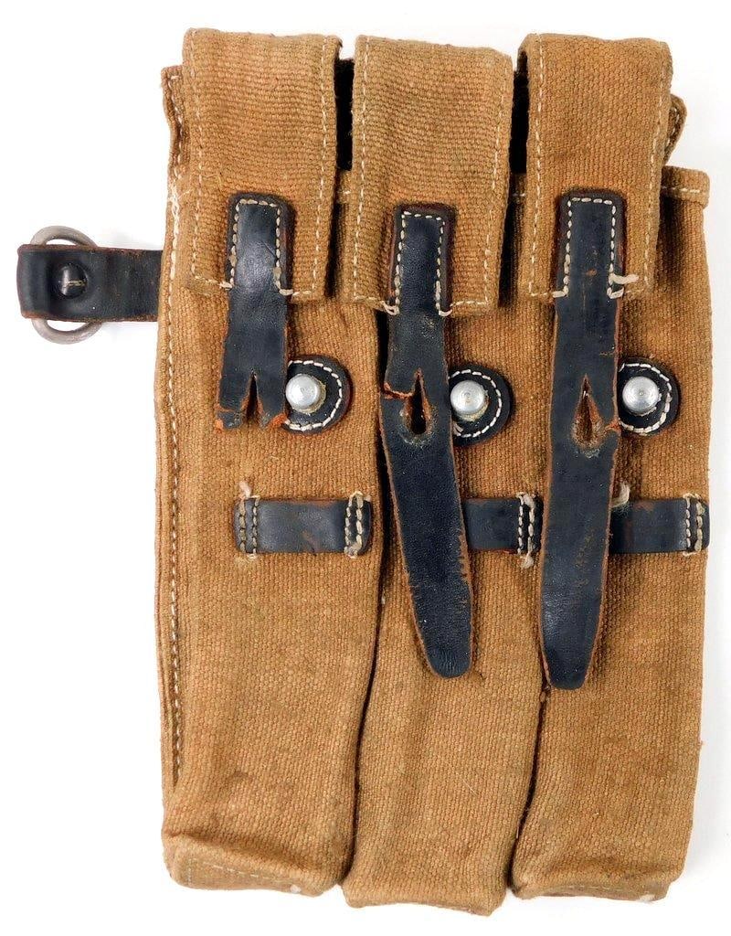 German WWI MP 40 Machine Gun Clip Pouch: Multi-piece machine-sewn tan canvas construction with black leather straps. Three leather straps on the front side show use and wear. Reverse is maker-marked bml 43 MP 38 u. 40 HFH. Two leather belt s