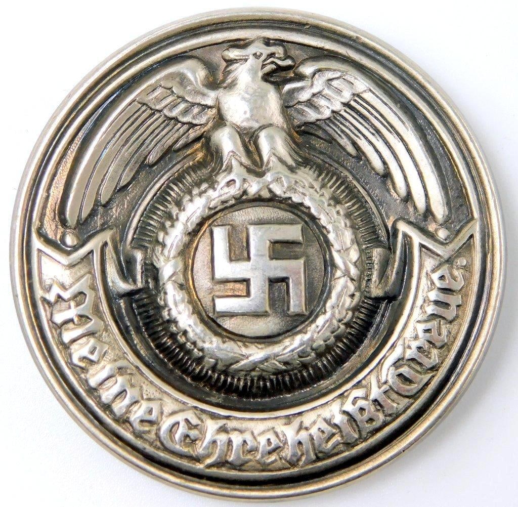 RARE German WWII Waffen SS Officers Belt Buckle: RARE. One-piece die-struck stamped nickel construction. Front shows a German eagle clutching a swastika. Reads Meine Ehre heist Treue (My Honor is Loyalty!). Reverse is maker-marked RZM SS 34/35.