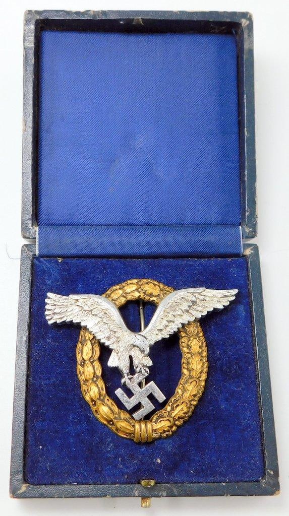 Scarce Cased German WWII Luftwaffe Pilot Observer Badge: Scarce. Front shows a Luftwaffe spread-winged flying eagle clutching a swastika. Both are surrounded by an oval oak leaf wreath. Reverse of the eagle is maker-marked SOG in a triangle. Thin vertical T