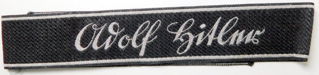 Scarce German WWII LAH ADOLF HITLER Division Enlisted Mans Cuff Title: A scarce Leibstandarte AH Division EM cuff title. Machine embroidered cloth woven bevo cotton construction. This was to have been worn on the lower left sleeve of the tunic. Front reads Adolf Hitler. 