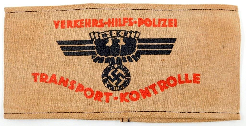 German WWII NSKK Police Transport Kontrolle Arm Band: One-piece machine-sewn printed cotton construction. Front shows a spread-winged German eagle clutching a swastika in its talons. Reads VERKEHRS HILFS POLIZEI NSKK TRANSPORT KONTROLLE. Measures 8 1/2 i