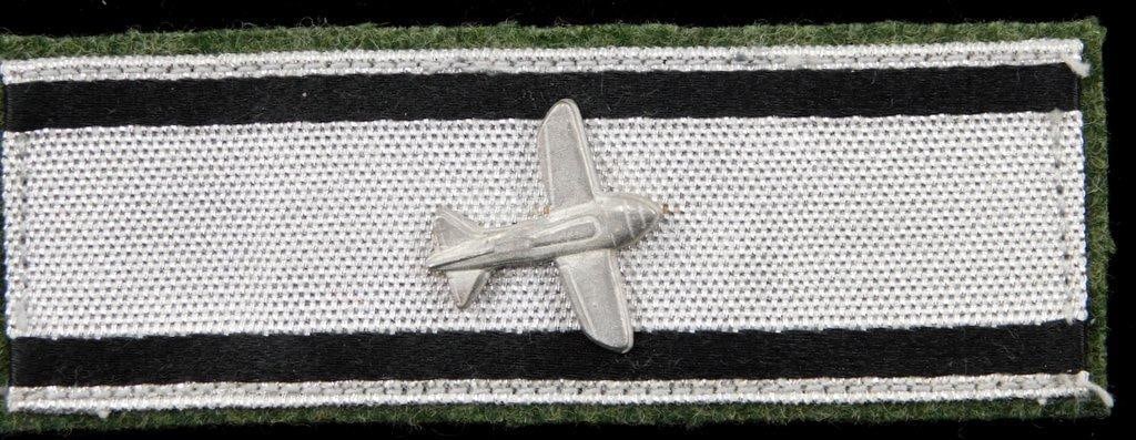 Silver Aircraft Destruction Strip: Awarded for single-handedly shooting down one airplane. This was to have been worn on the upper left sleeve of the uniform. Two black cotton woven stripes along the top and bottom borders. OD gre