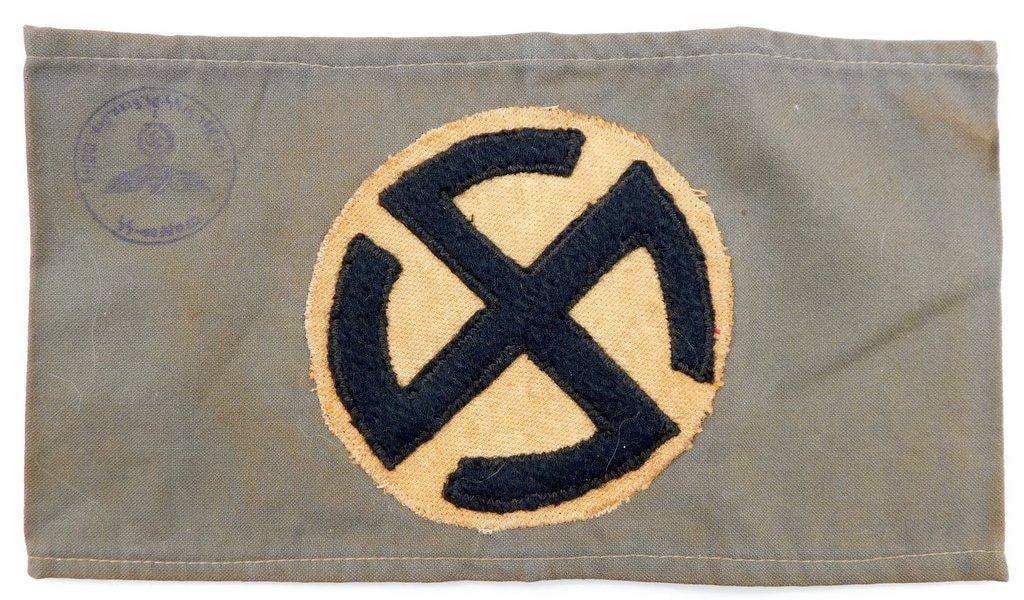 German WWII Foreign Volunteer Swastika Arm Band: Three-piece machine-sewn cotton construction. German eagle stamp in black ink on the lower right-hand corner. This was to have been worn on the upper left sleeve of the uniform. Front shows a cog whee