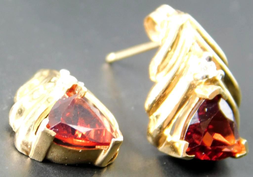 14K Yellow Gold Earrings w/ Trillion-Cut Tourmaline Stones and Diamond Accents: 14K yellow gold stud earrings featuring a trillion-cut tourmaline stone as the central element, accented by a small round-cut diamonds on each earring The earrings are designed with an elegant gold se