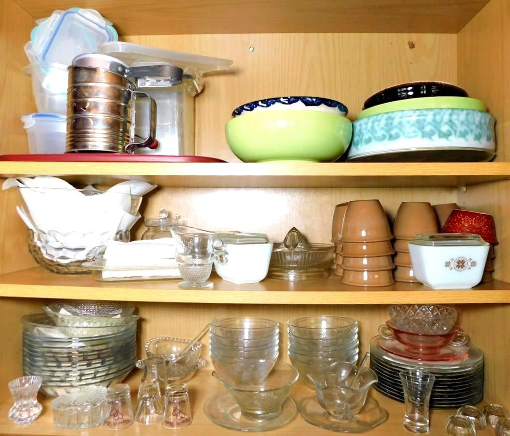 Glassware, Kitchen Items, and Pyrex 501-B Containers: Various kitchenware items including multiple glass dishes, bowls, and cups in clear and colored glass Group includes brown ceramic bowls, juicer, a vintage metal flour sifter, plastic storage containe