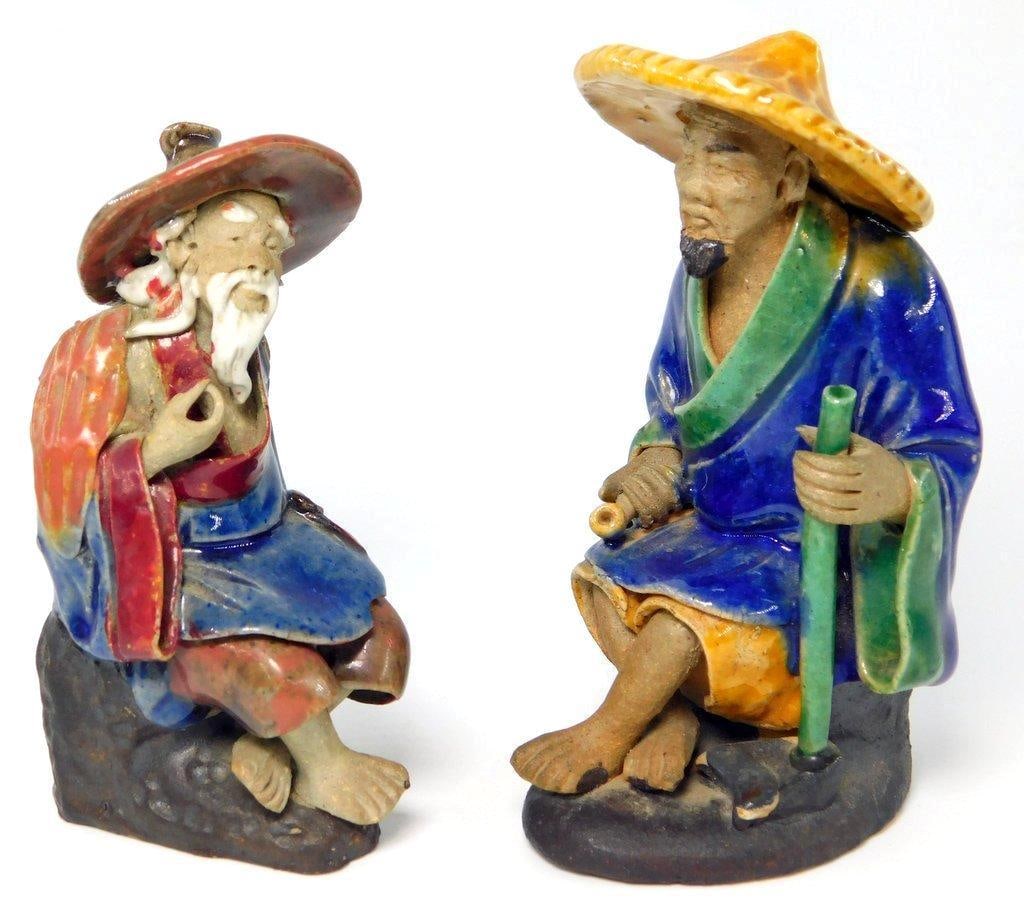 Pair of Chinese Mudmen Sage Figurines: The shortest figure depicts a seated Chinese man, likely an old sage or fisherman, in traditional clothing Very good condition and finish Stamped CHINA on base The other is also a seated Sage or