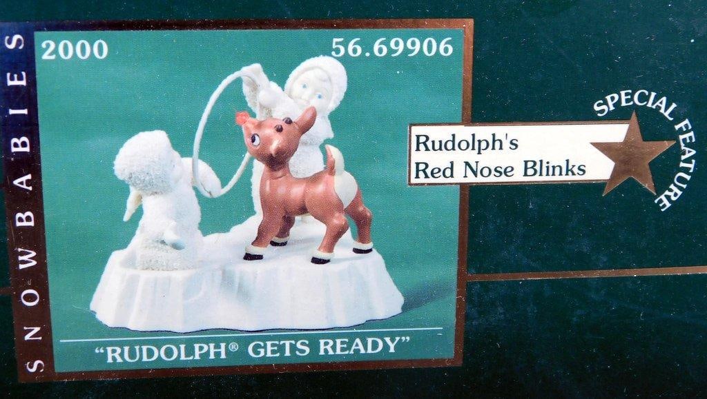Department 56 Snowbabies 'Rudolph Gets Ready' Figurine w/ Blinking Nose: Department 56 Snowbabies Rudolph Gets Ready figurine from The Guest Collection Features Rudolph with a blinking red nose and Snowbabies figures on an ice-like base Includes original packagi