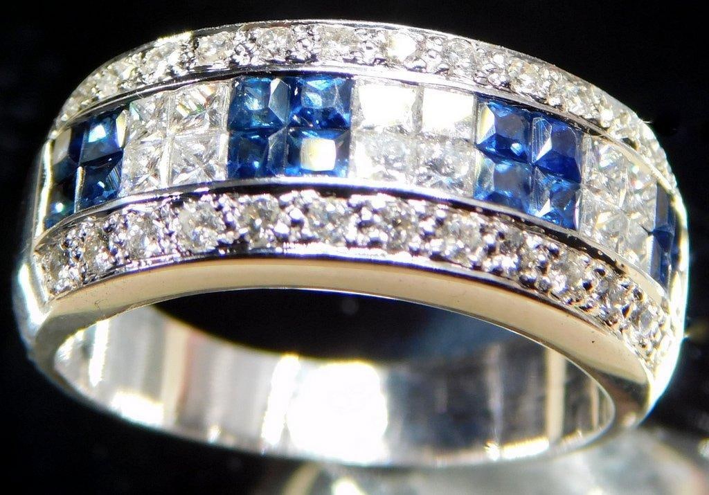 18K White Gold Diamond and Sapphire Ladies Ring: Jeweler tested 18K white gold band ring featuring a channel-set design with alternating square-cut blue sapphires and diamonds in two rows White gold with intricate cut-out patterns on the inner band