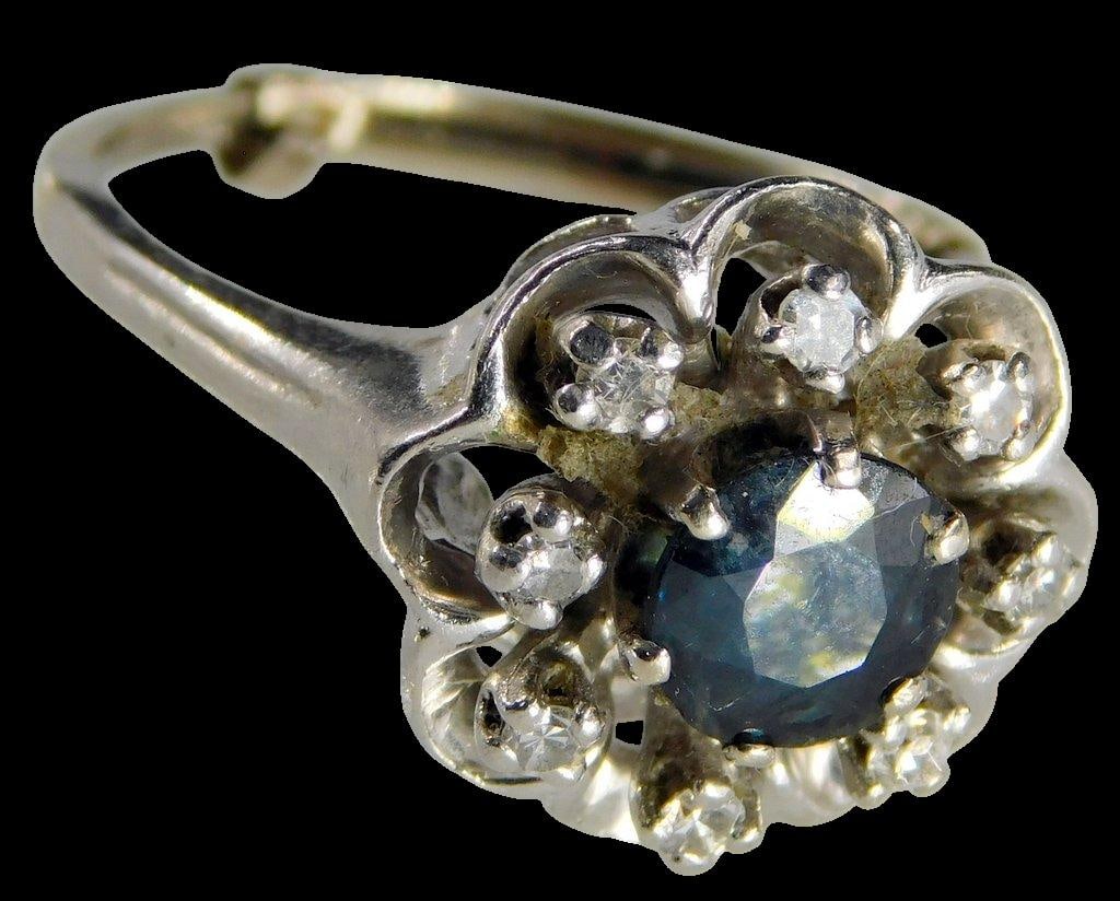 Ladies 14K Gold, Diamond and Topaz Ring: 14K white gold right with topaz center stone surrounded by eight diamonds Diamonds and topaz tested Tested 14K Marked as shown, illegible to us Size 8 w/ adjuster 6.4 dwt View all photos to see how