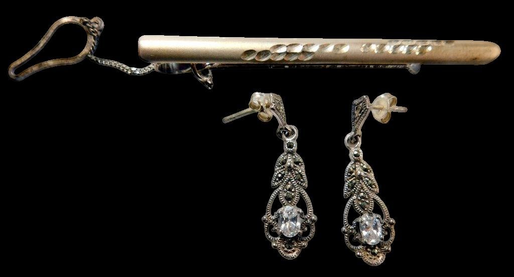Sterling Silver Marcasite Earrings and Tie Clip: A pair of sterling silver drop earrings with marcasite embellishments and central clear glass stones, showcasing detailed filigree designs Accompanied by a vintage tie clip with a chain and secure