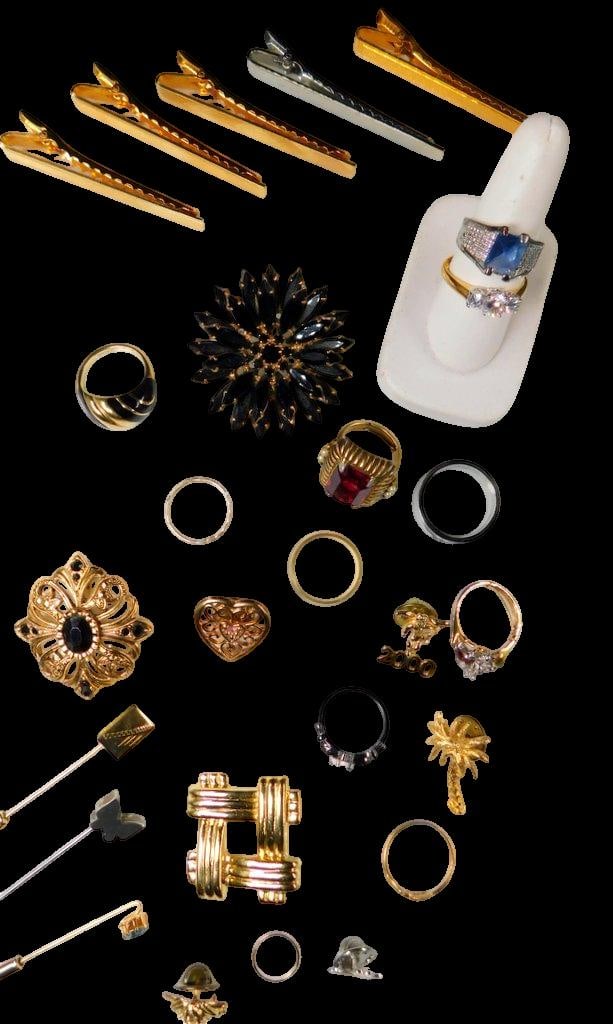 Jewelry, Including Rings, Brooches, Clips, and Miscellaneous Pieces: A varied collection of jewelry, including both costume and fine pieces The set features multiple rings, a selection of brooches, gold-toned tie clips, and decorative pins Notable items include a