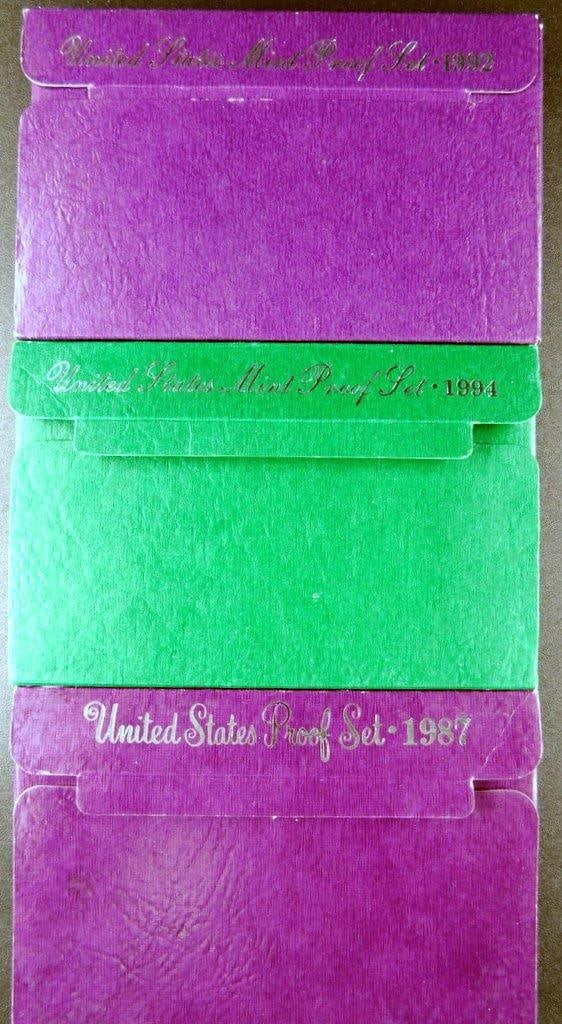 United States Mint Proof Sets (1987, 1992, 1994) in Original Packaging: Three United States Mint Proof Sets from the years 1987, 1992, and 1994 Each set is housed in its original colored hard cardboard presentation case with metallic embossed lettering These sets are typi