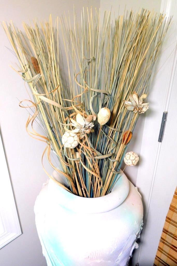 Large Decorative Ceramic Vase w/ Dried Floral Arrangement: A decorative ceramic vase featuring a gradient finish in soft pastel tones and textured embellishments The vase contains a dried floral arrangement with natural elements, including ornamental seed