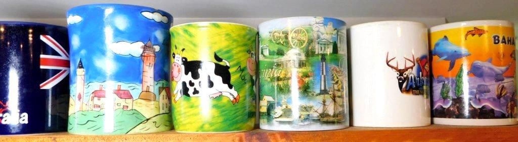 Six Souvenir Coffee Mugs w/ Various Themes: Never used Six souvenir coffee mugs, each featuring unique designs and motifs Includes themes from worldwide locations: Australia, Bahamas, and more, with illustrations such as a cow, landmarks,