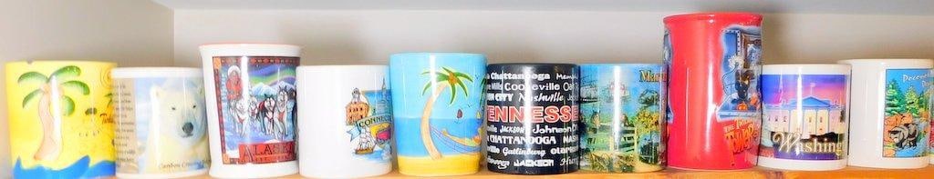 Souvenir Mugs Featuring U.S. States and Landmarks, (10): Ceramic souvenir mugs showcasing various U.S. states and landmarks, including Alaska, Tennessee, Maryland, Washington D.C., and Connecticut Designs feature unique imagery such as polar bears, dog