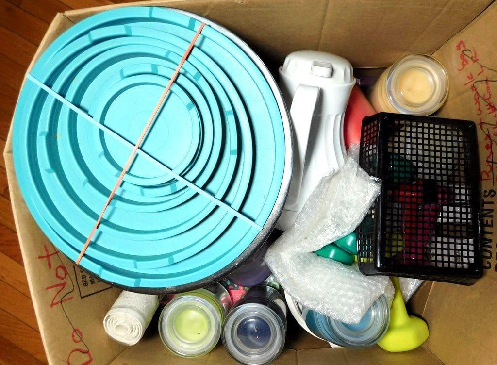 Household Items Including Mixing Bowls, Dumbbells, and Candles: Unique grouping as found at the estate Household items including a set of stainless steel mixing bowls with blue plastic lids, an electric hand mixer, multiple colored scented candles, a set of small