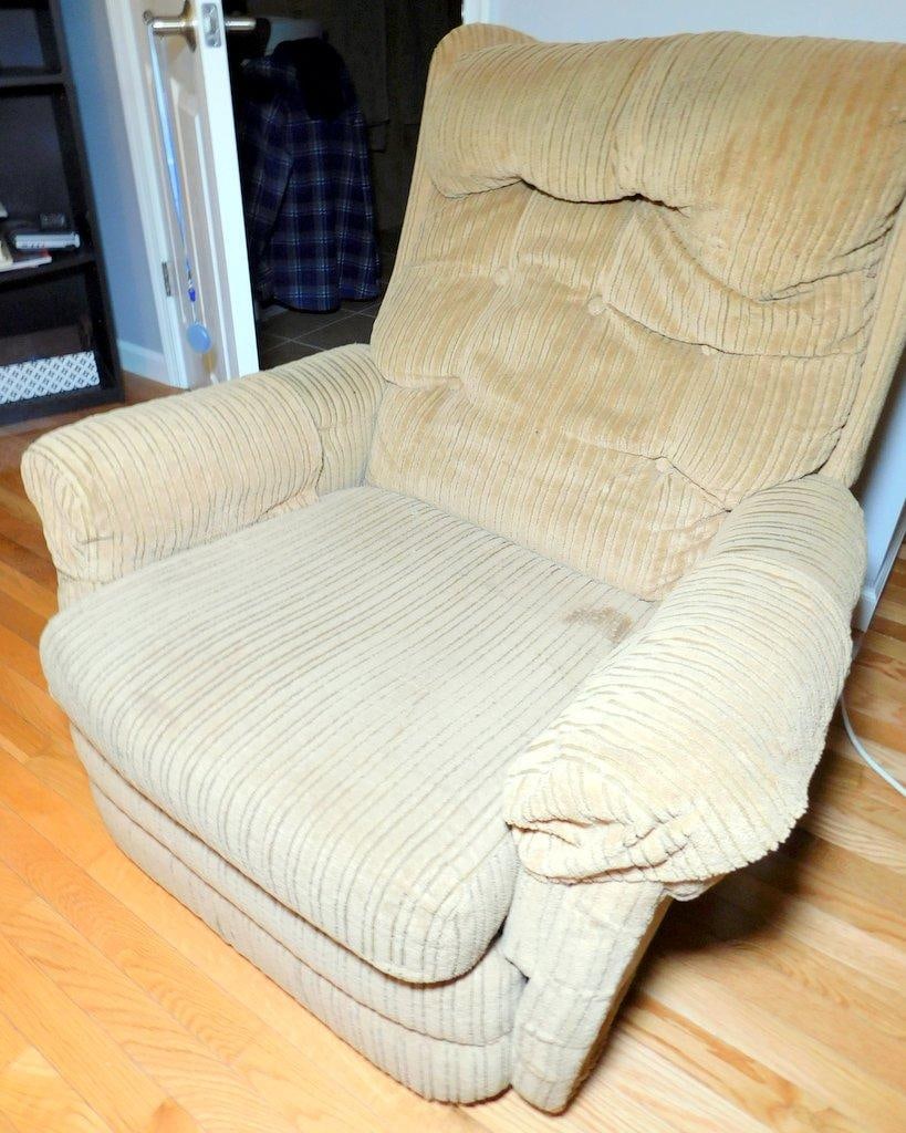 Beige Corduroy Upholstered Recliner Armchair: A cushioned armchair with a beige corduroy fabric upholstery The recliner features tufted detailing on the backrest and padded armrests for additional comfort It shows visible signs of wear and