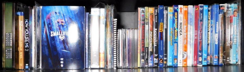 DVDs Including Smallville, High School Musical, and Pixar Films: DVDs featuring a diverse range of titles, including the complete series of Smallville, popular Pixar films such as Ratatouille and Monsters University, Disney movies, and various other genres The