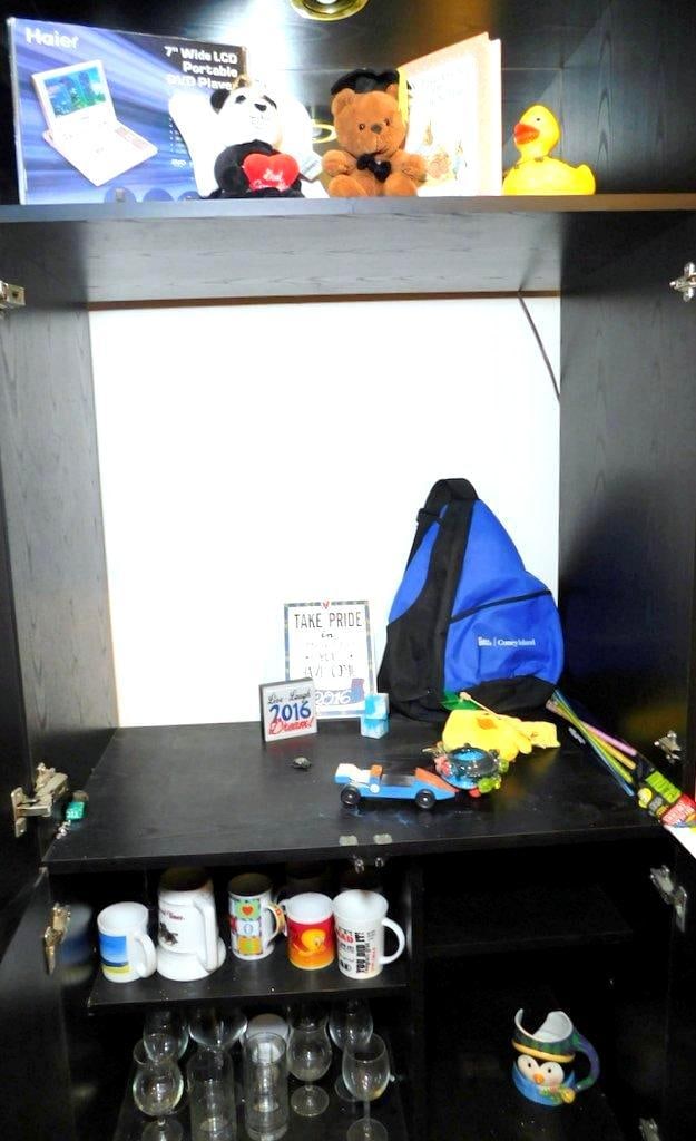 Items Including Haier Portable DVD Player, Plush Toys, and Home Decor: Group lot featuring a 7-inch Haier portable DVD player in its original box, two plush toys (a graduation bear and a God Loves You panda), and a variety of household items Includes a Peter Rabbit