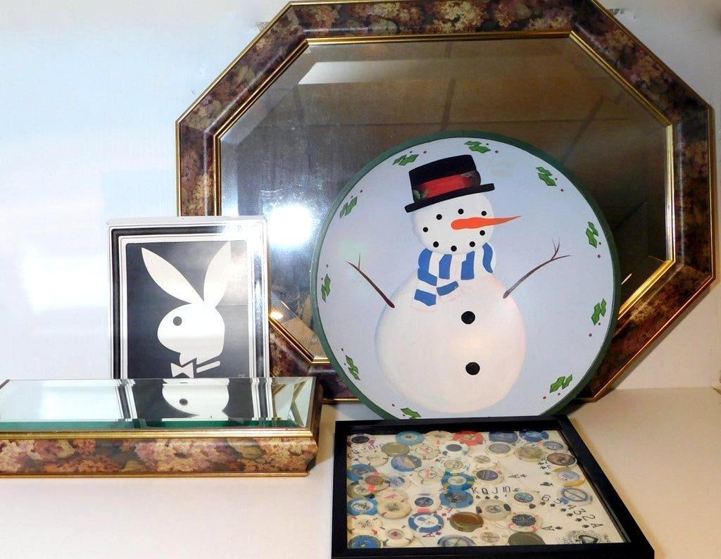 Decorative Items Including Octagonal Mirror, Snowman Plate, Casino Chip Display, and More: An octagonal wall mirror with floral-patterned frame, PlayBoy logo decor piece, a circular snowman-themed decorative plate, a framed display of assorted casino chips arranged alongside playing cards,