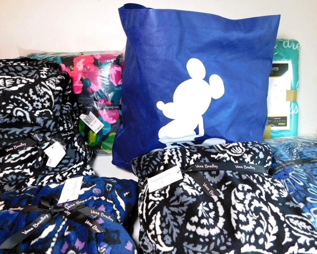 Vera Bradley and Rose Home Fashion Throw Blankets: Multiple throw blankets, primarily by Vera Bradley, featuring vibrant patterns such as floral and paisley, each retaining original tags and packaging Also included is a Rose Home Fashion throw