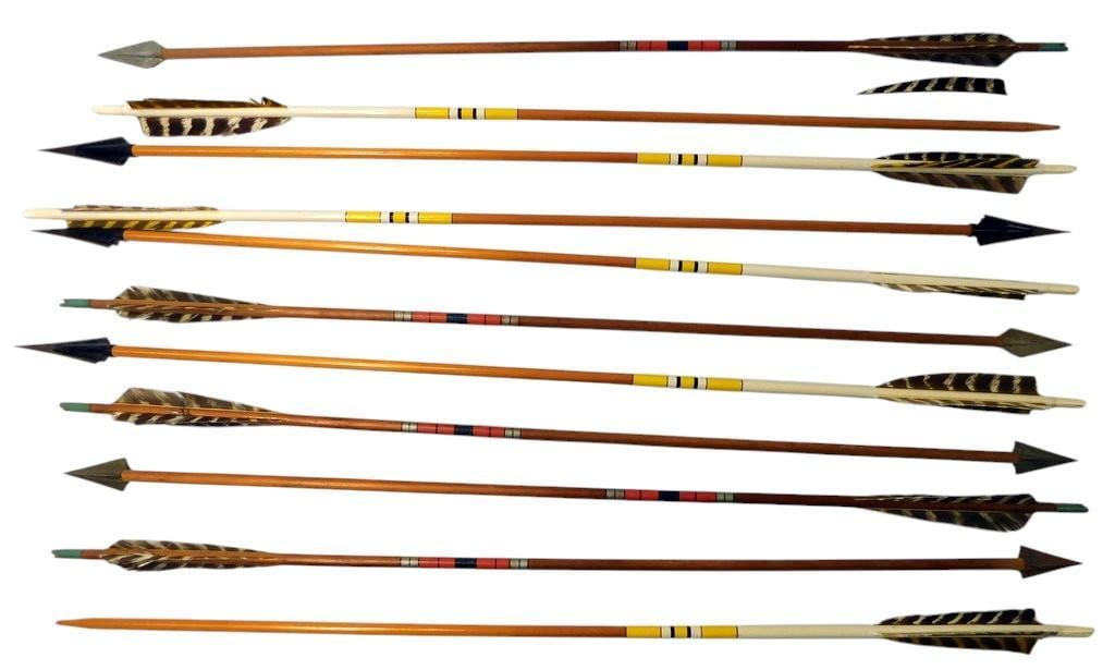 Wood and Aluminum Arrows w/ Bow Arm Guard: Traditional-style wood arrows featuring feather fletching and metal tips, paired with Easton camo-aluminum arrows marked XX75 Camo Hunter and Made in USA Includes a camo-patterned bow arm guard with