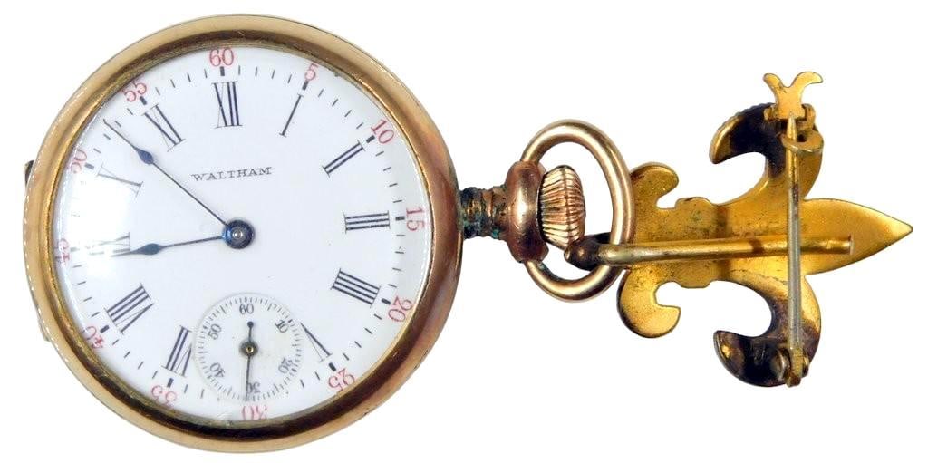 Antique Waltham 21-Jewel PocketWatch w/Fleur-de-Lis Lapel Pin: American Waltham Watch Co. Traveler Grade Mechanical Pocket Watch Waltham pocket watch featuring 21 jewels, with a white enamel Roman numeral dial and seconds subdial Comes in a gold-tone case with or