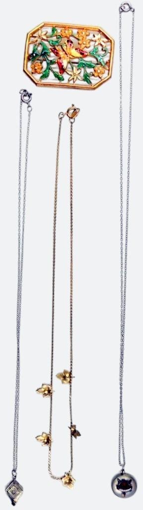 Enamel Brooch and Necklaces Featuring Various Motifs: A gold-tone enamel brooch with vibrant butterfly and floral designs, one gold-tone chain necklace adorned with detailed leaf charms, one chain with a geometric pendant featuring a clear and a dark