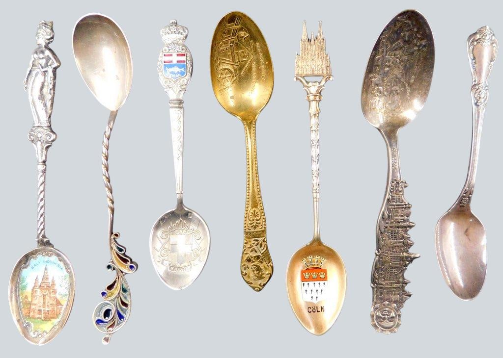 Decorative Collectible Souvenir Spoons Grouping: Eight collectible souvenir spoons featuring various designs, including enamel details, embossed patterns, and intricate motifs Designs represent different cities and landmarks such as Cologne and