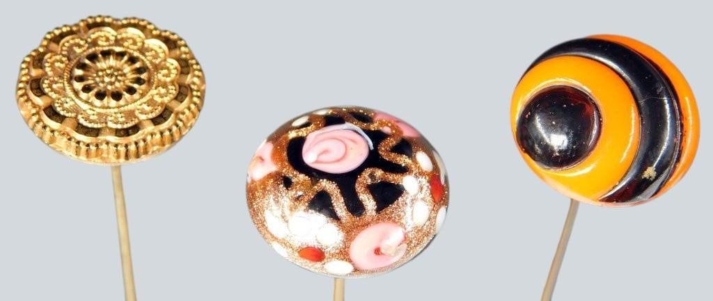 Decorative Hatpins w/ Ornate Heads, (3): Three long decorative hatpins featuring distinct ornate heads Includes a gold-tone filigree design pin, a colorful glass head with orange and black swirl design, and a black glass head with pink and