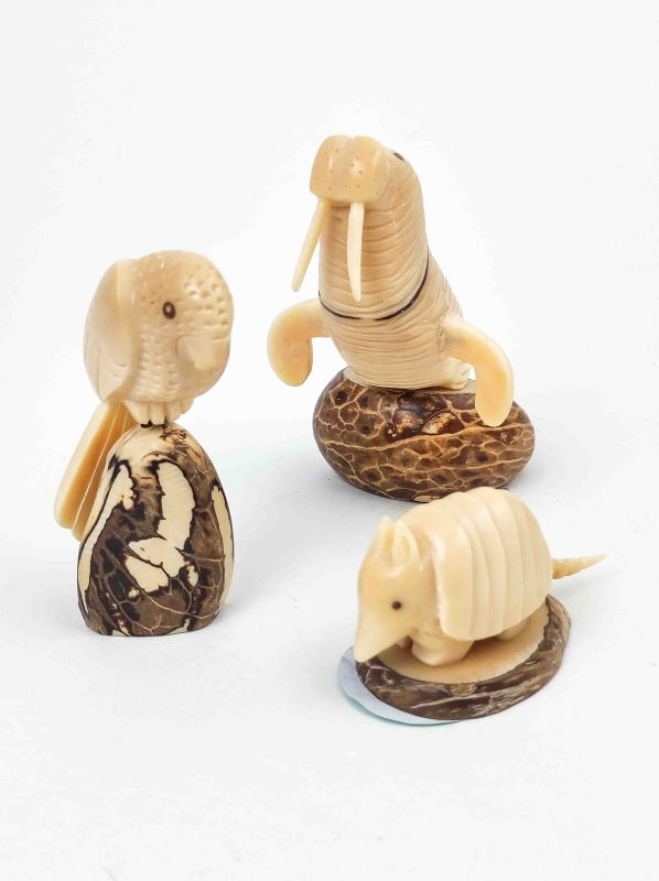 Drei Stk. Nussfiguren: Drei handgefertigte Figuen, geschnitzt aus Nussholz, verm. Tagua Nuss, Motive 1x Walross, 1x Papagei, 1x Warzenschwein, 1950er Jahre Südamerika Interne Nr. A0170500006