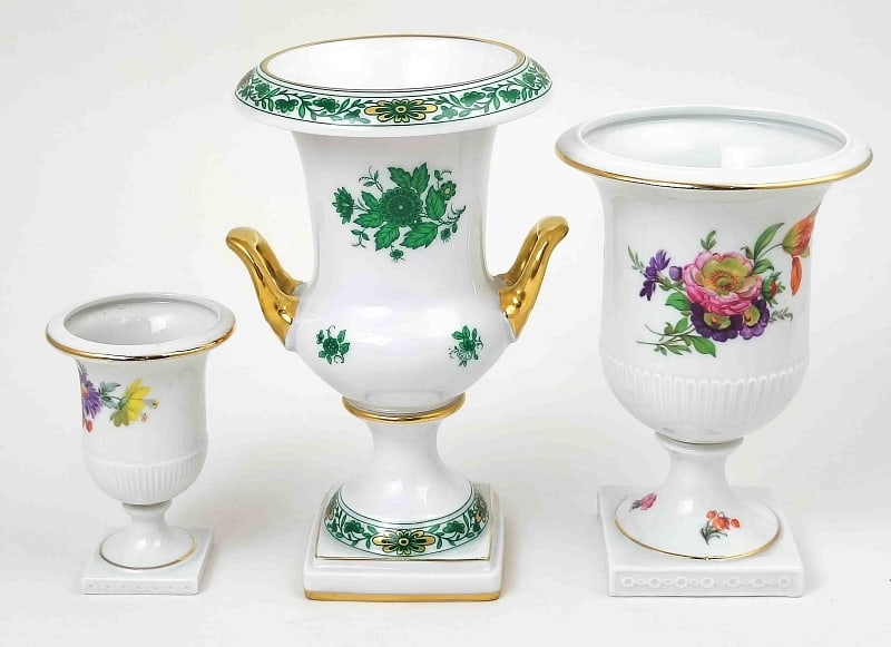 Drei Porzellan Pokal Vasen: Drei Porzellan Pokalvasen, davon 2x mit seitlichen Handhaben, polychrom bemalt mit Ziervergoldung, 2x Fürstenberg, Maße , 1x ca. 15,5cm, Ø Öffnung oben ca. 8cm, 1x ca. 9cm hoch, Ø Öffnung oben