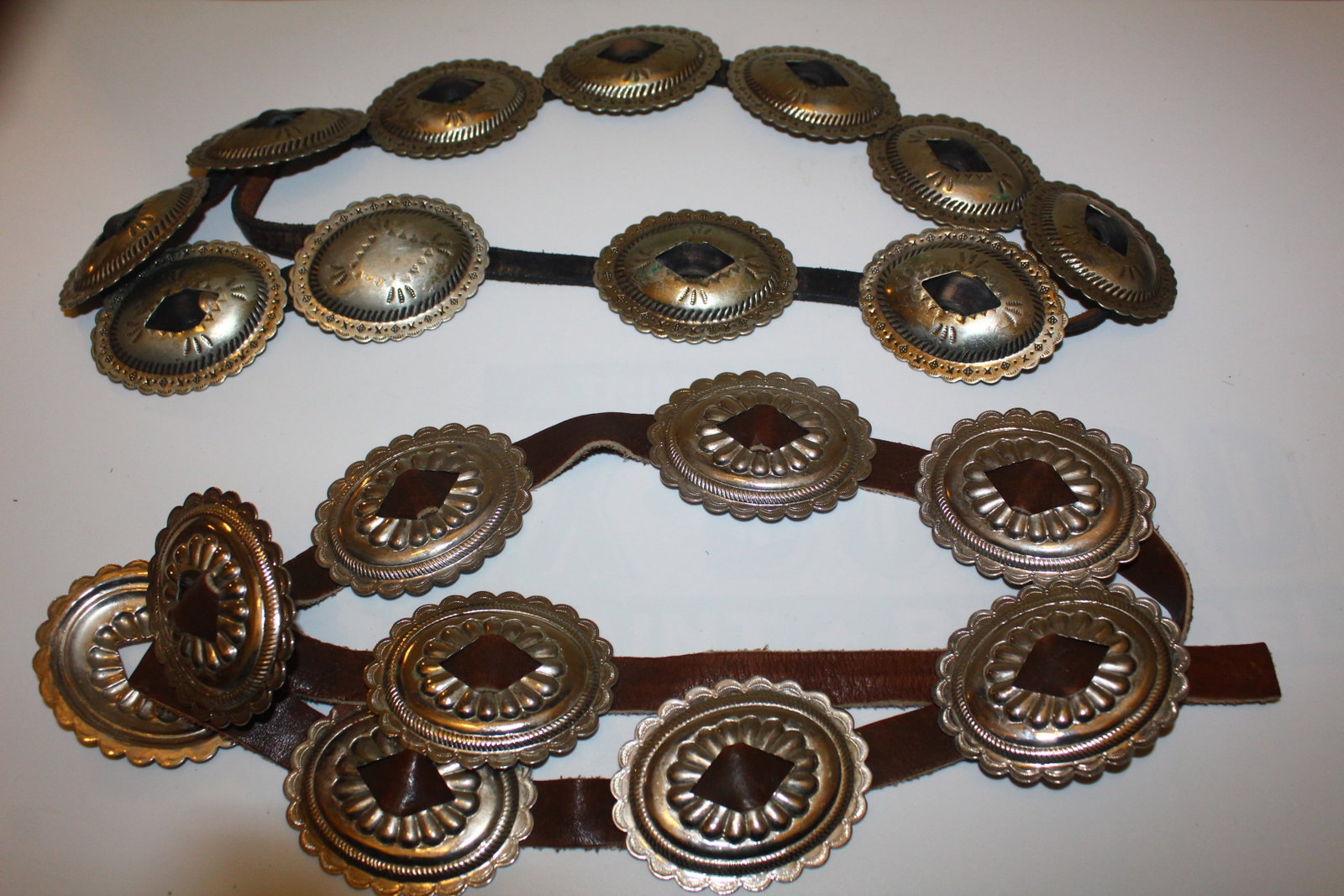 Lot of 2 Conchas Belts: Two phenomenal concha belts are included in this lot. One leather belt is brown. The other is black. Both include silver conchas. Put one at the waist of cute skirt had some cowboy boots, and you are 