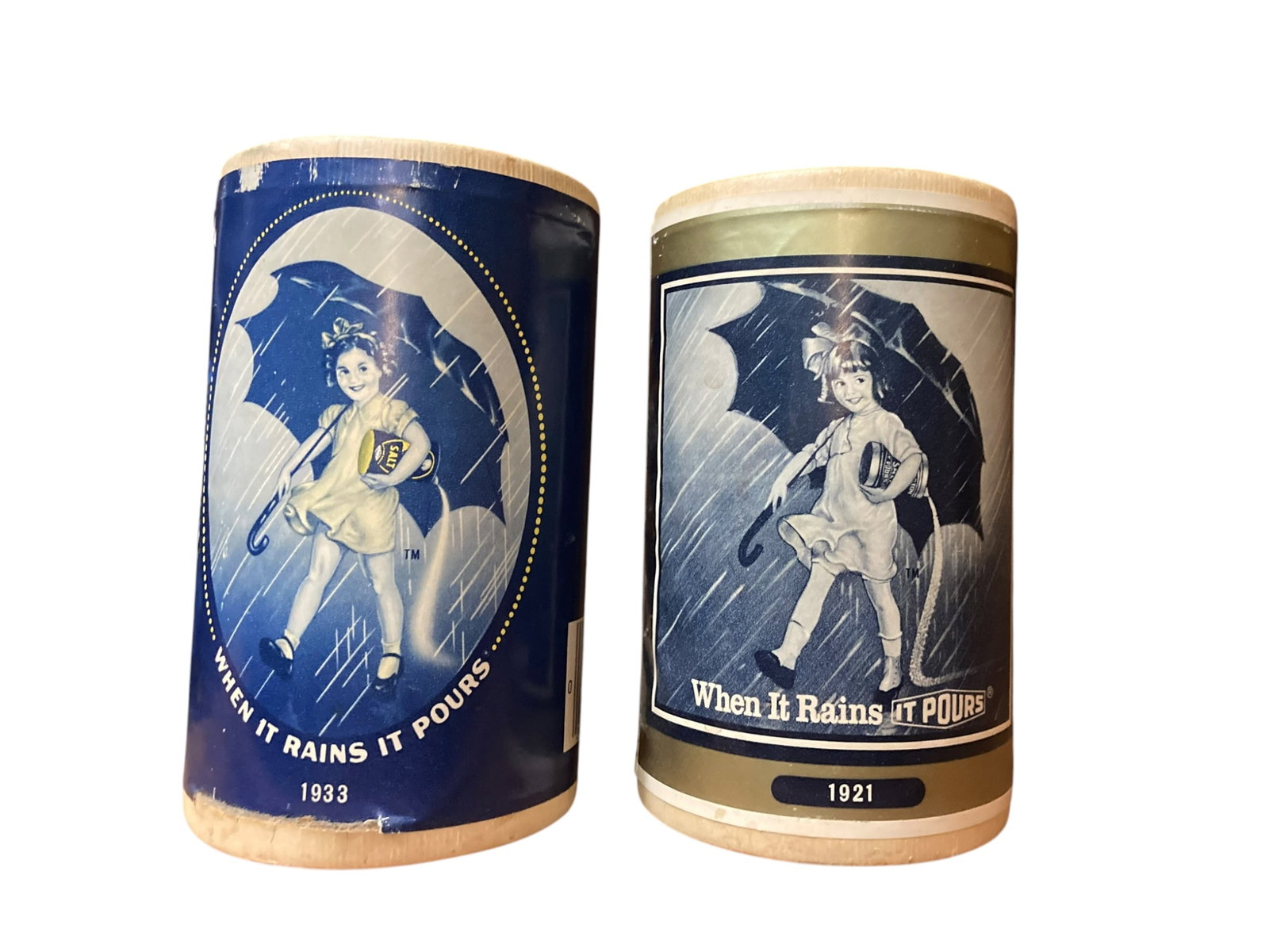 SET OF 2 Vintage Commemorative Morton Salt Containers: Lot includes 2 commemorative Morton Salt containers featuring the different Morton Umbrella Girls respective to the year. Includes the years 1933 and 1921. In fair to good condition.