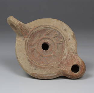 Roman factory oil lamp depicting Myrtle wreath with makers mark, Type Bussière D II 1: ITEM: Factory oil lamp depicting Myrtle wreath with makers mark, Type Bussière D II 1 MATERIAL: Pottery CULTURE: Roman PERIOD: 1st - 3rd Century A.D DIMENSIONS: 45 mm x 77 mm x 113 mm CONDITION: