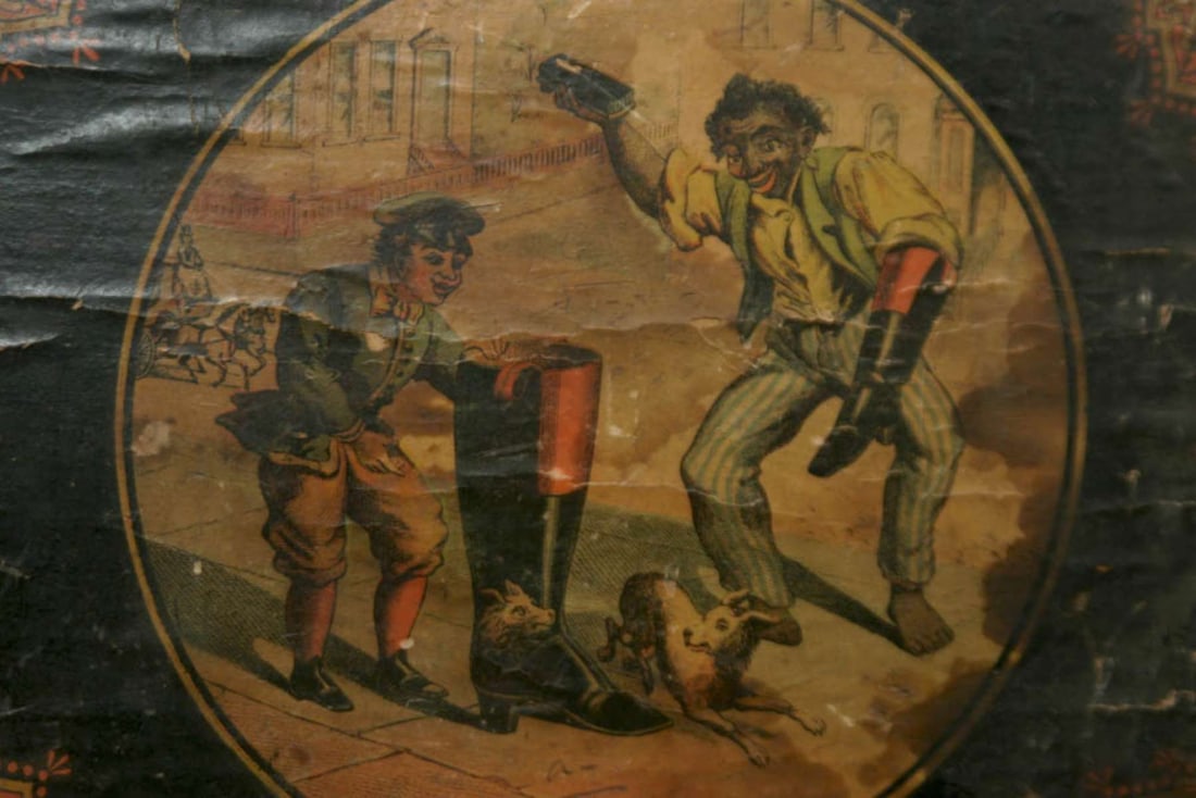 antique Black Americana advertisement: antique paper glued on wooden board original ad depicting an African American shoe shine man and a boy looking into a riding boot so shiny, it reflects a dog, scaring it, lower right