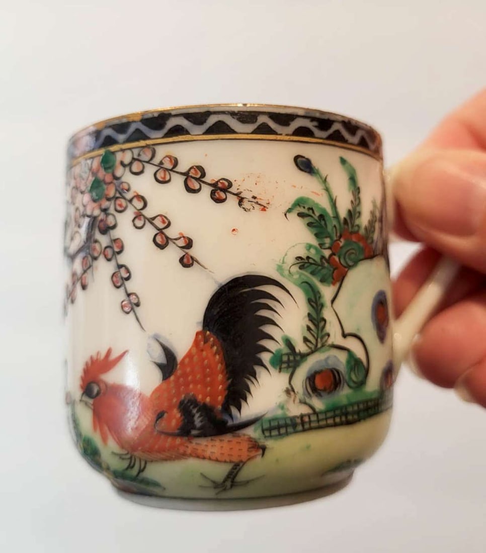 antique Asian rooster porcelain cup and saucer: vintage or antique Chinese demitasse set of a handled cup and matching saucer both with rooster design and marked Hong Kong underneath
