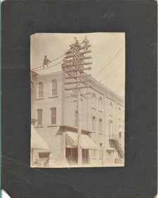 unusual antique mounted photo of men on top of electric pole