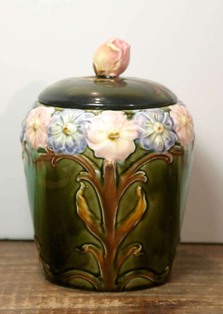 antique Majolica tobacco jar or humidor: beautiful antique pottery lidded jar with floral knob and abstract flower design with leaves on the body of the jar, numbered on the bottom as shown about 7 1/4" tall overall with lid