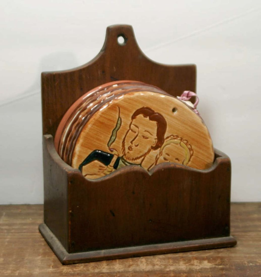 vintage redware set of wall hung plaques: lot of 7 vintage trivets or coasters in a home made wooden wall hung box, Folk Art redware pieces with polychrome glossy glaze designs of Amish farm life, depicting people (men, wome