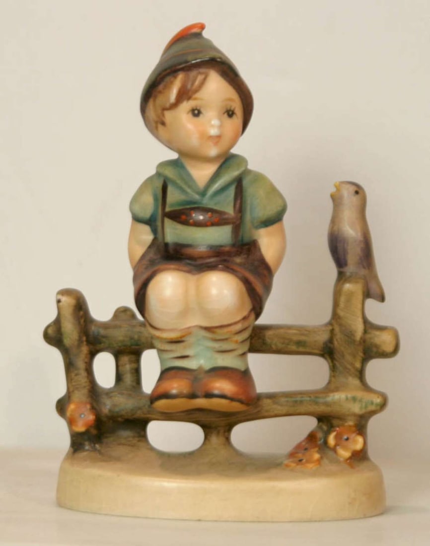 vintage Goebel Hummel figurine: shaped like a boy sitting on a fence with a bird, marked as shown 1938 by Goebel W. Germany and blue bee in Vabout 3 3/4" tall
