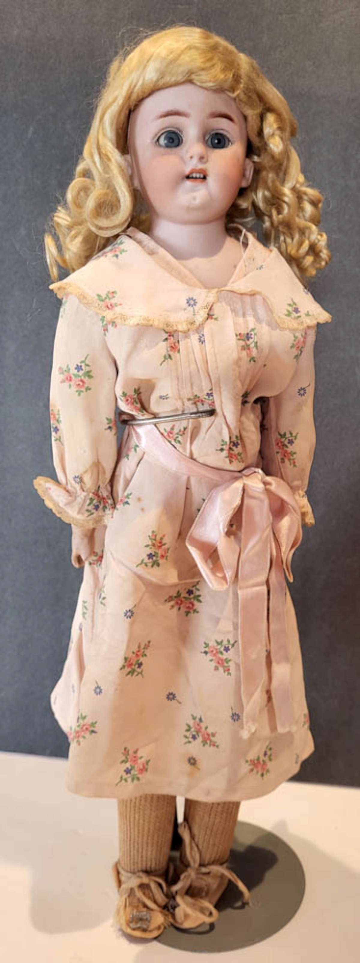 antique German porcelain head girl doll: bisque or porcelain head doll with illegible marks (can make out only Germany), with open mouth and teeth showing, blue eyes and hand painted eyelashes, blonde wig and what looks lik