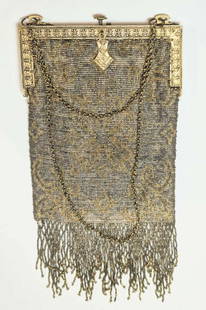 Art Deco period handbag or purse: vintage or antique, ca. 1920's micro-beaded bag with a chain holder, gilt finish push closure with abstract floral or flower design and fringe on the bottom, gold and silver ton