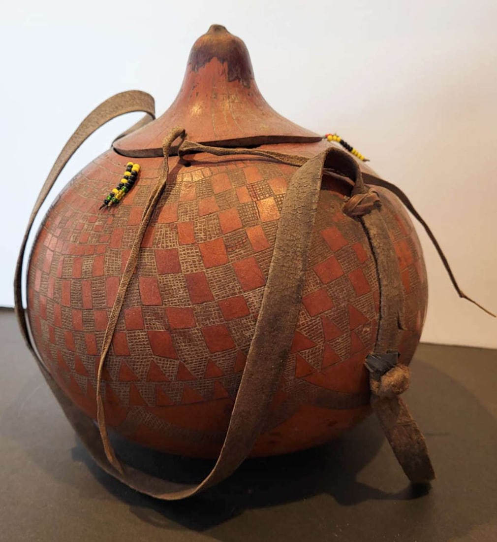 vintage African milk drinking canteen: vintage or antique African gourd or calabash canteen with leather carrying strap and yellow and black trade bead design